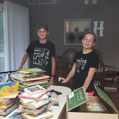 Youth Volunteers cleaning books and stamping, and stocking the lending library.